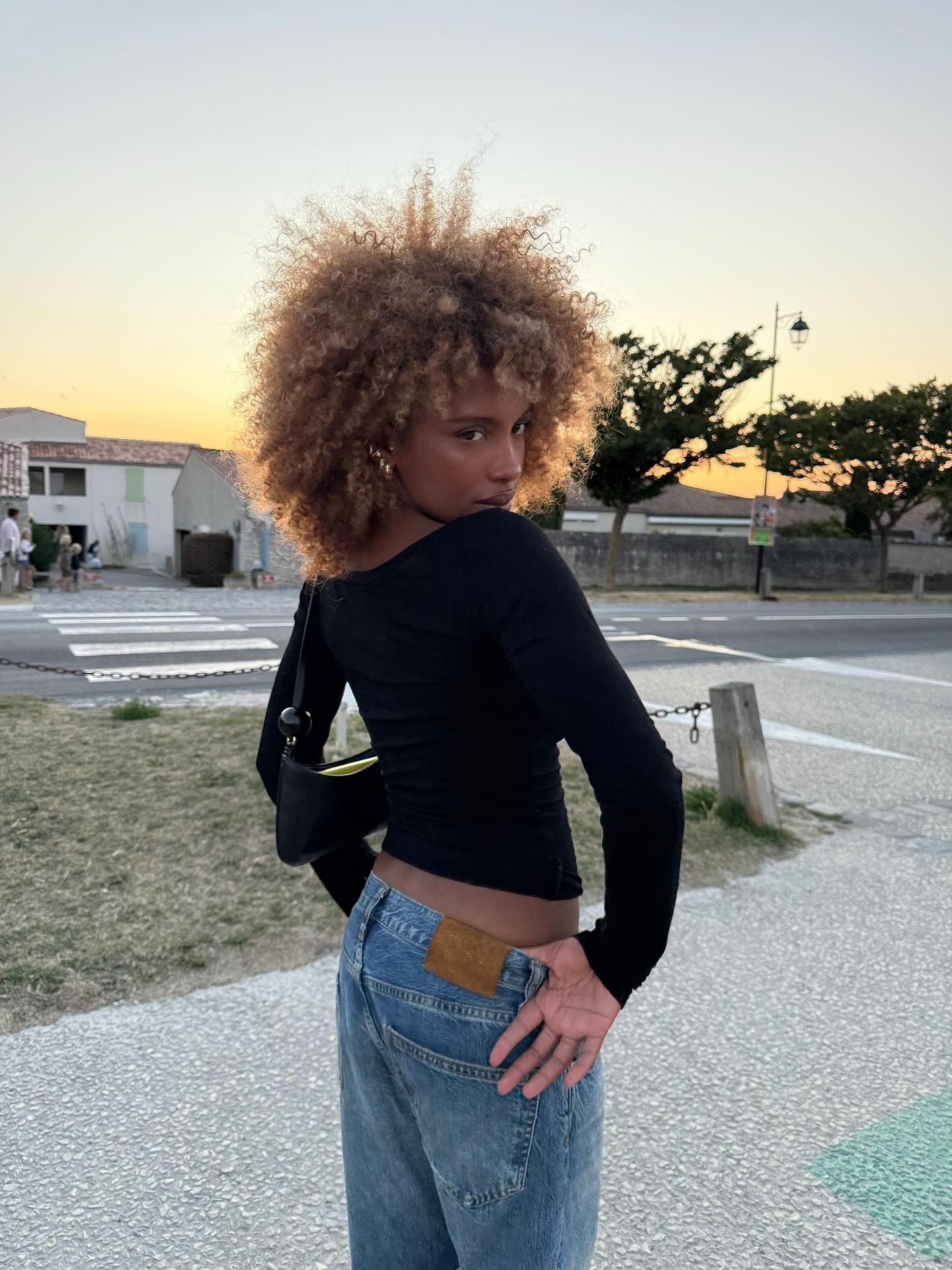 A woman with curly hair and a short, serrated haircut