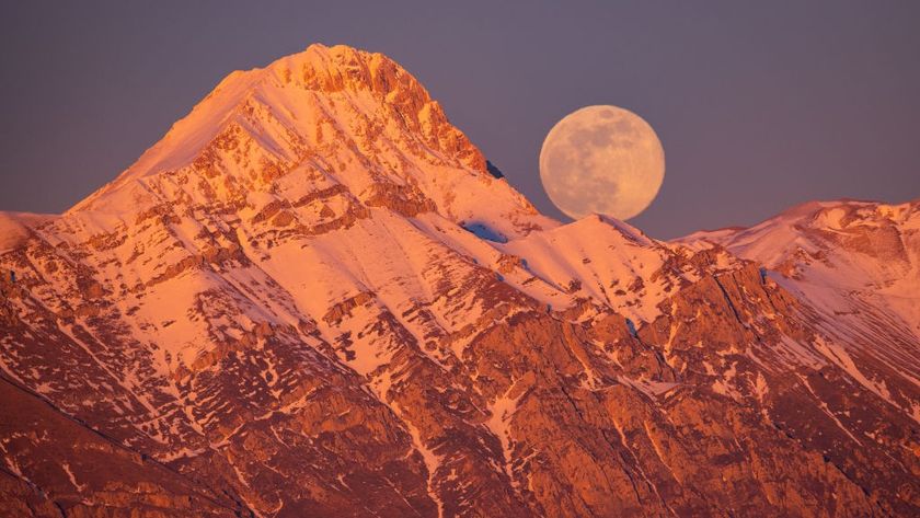 Wolf moon rising next to Corno Grande and Pizzo Cefalone peaks in Italy.