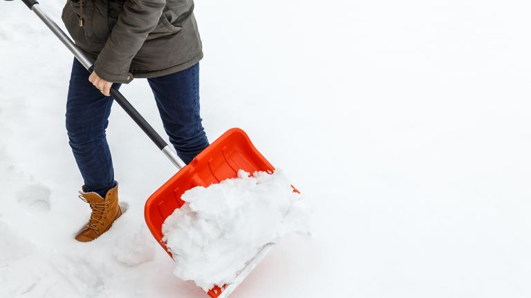 Woman with shovel cleaning snow