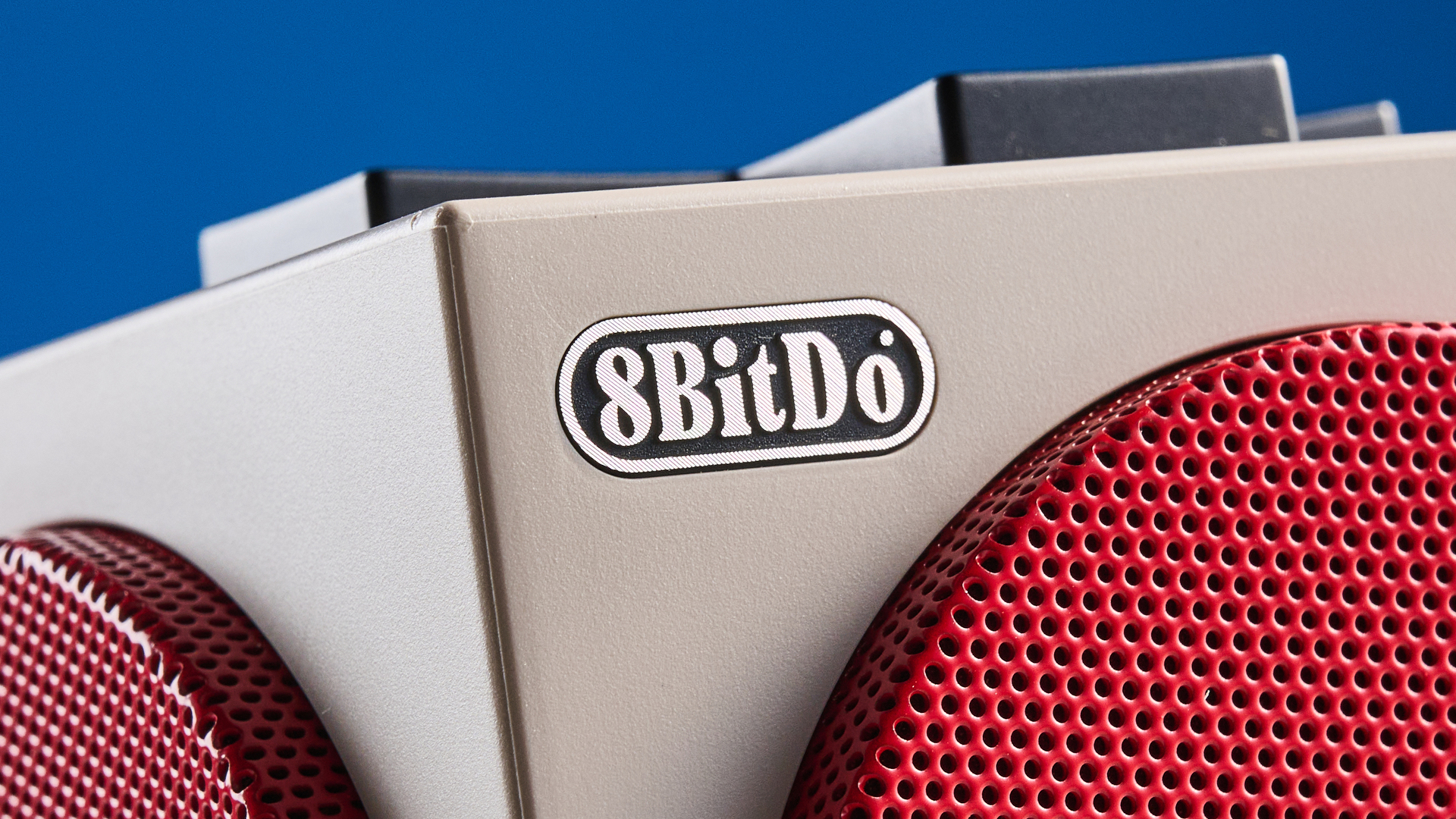 A beige, red and black 8BitDo Retro Cube 2 Bluetooth speaker