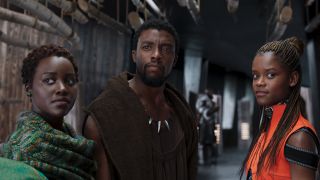 Lupita Nyong'o, Chadwick Boseman, and Letitia Wright hanging out in a hallway in Black Panther.