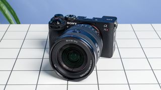 The Sony A7CR on a white table with a blue wall in the background