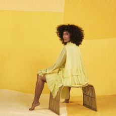 Yellow, Shoulder, Fashion, Furniture, Fashion design, Joint, Sitting, Outerwear, Room, Dress, 