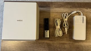 XGIMI Horizon Ultra with power cable and remote control on a wooden desk
