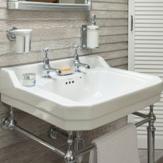 White bathroom basin with a wood panel wall behind