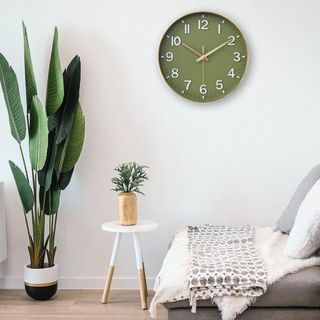 A green modern wall clock in a minimalist liing room