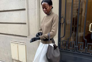 Woman in sweater, skirt, and gloves