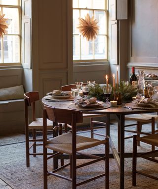 Cozy dining room with christmas decorations, candles, foliage