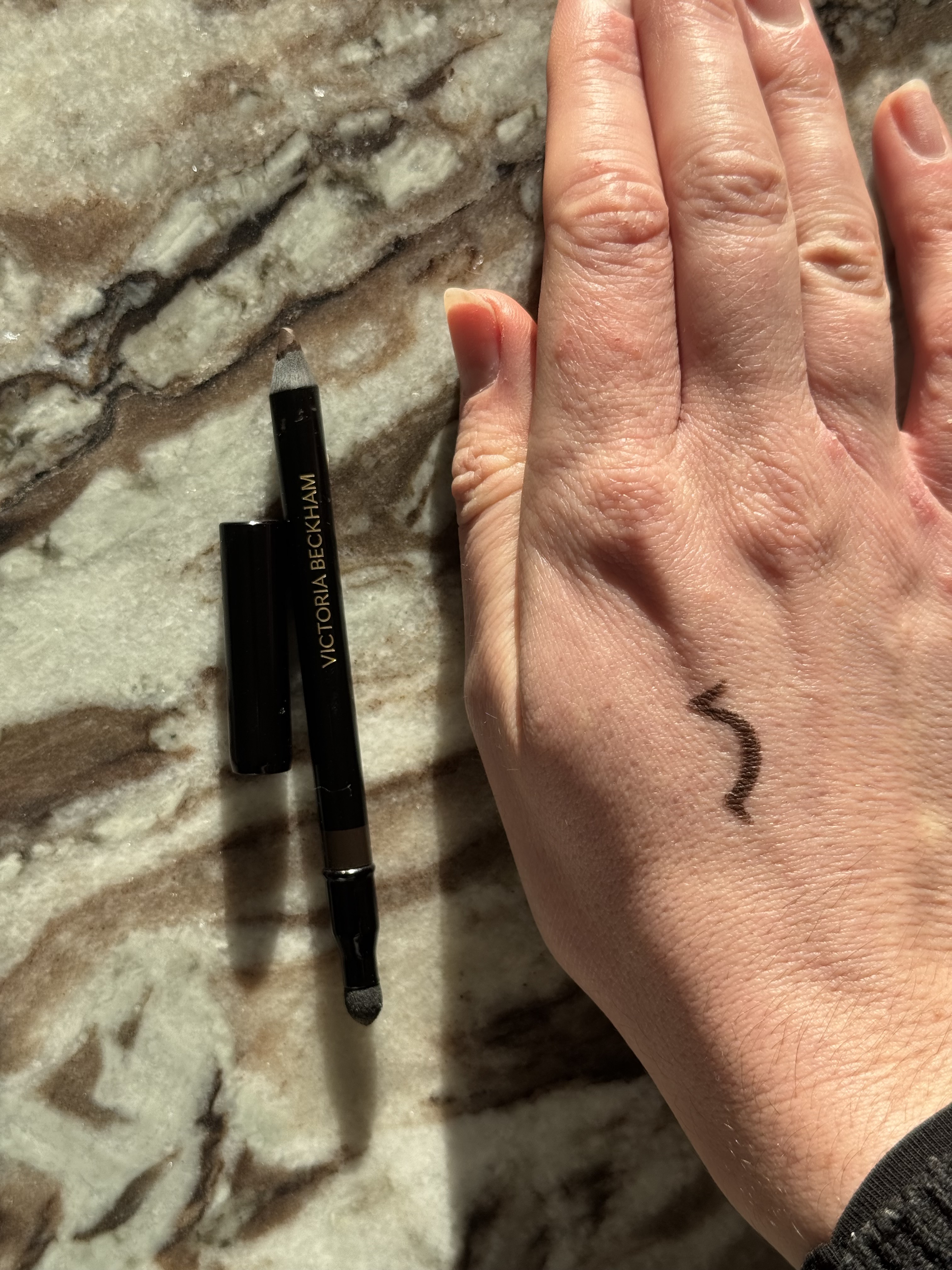A swatch on hand of the victoria beckham beauty satin kajal liner in shade cocoa