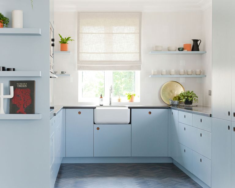  u-shaped kitchen with light blue cabinets and a white Belfast sink in front of a window