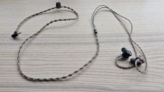 FiiO FP3 wired earbuds on a wooden surface