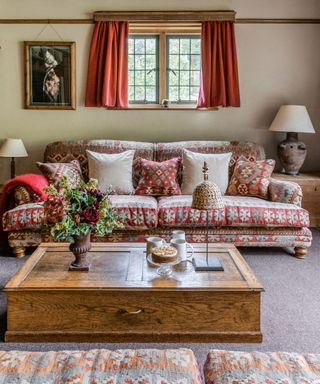 Country living room with grey carpet and red patterned sofa