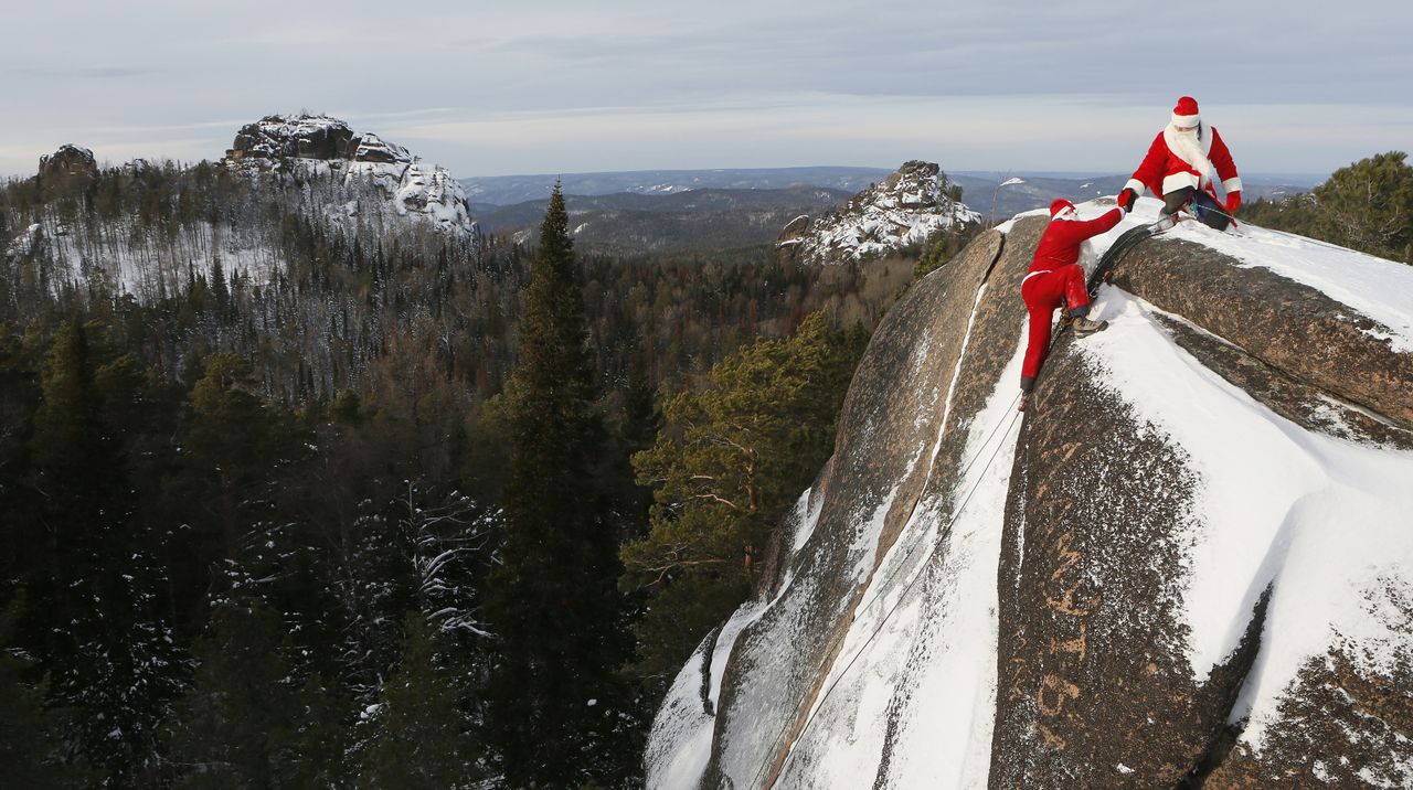 A member of the &amp;quot;Sibspas&amp;quot; Siberian search and rescue group dressed as Santa Claus (L), shakes hands with his teammate, dressed as Father Frost, the Russian equivalent of Santa Claus, as they 