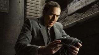 Ben Reilley (Nicolas Cage) looks at his mask on Spider-Noir.