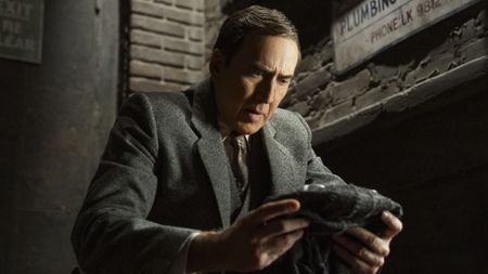 Ben Reilley (Nicolas Cage) looks at his mask on Spider-Noir.