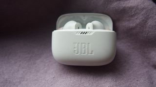the jbl tune 230nc true wireless earbuds in their charging case