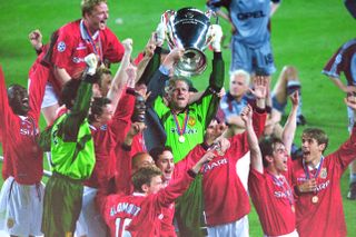 Peter Schmeichel lifts the Champions League trophy as Manchester United's players celebrate their dramatic late victory over Bayern Munich in the 1999 final at Camp Nou.