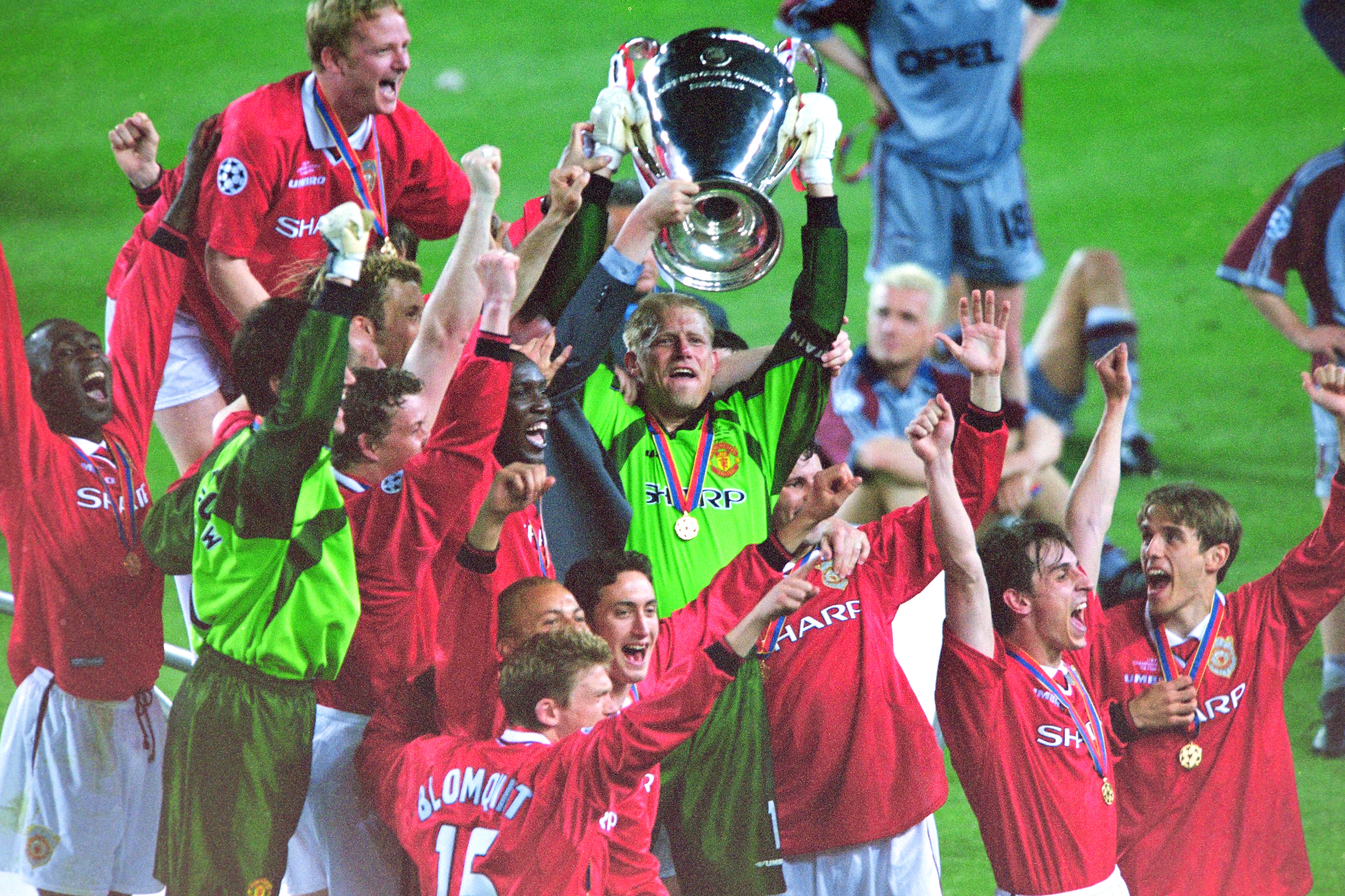 Peter Schmeichel lifts the Champions League trophy as Manchester United's players celebrate their dramatic late victory over Bayern Munich in the 1999 final at Camp Nou.