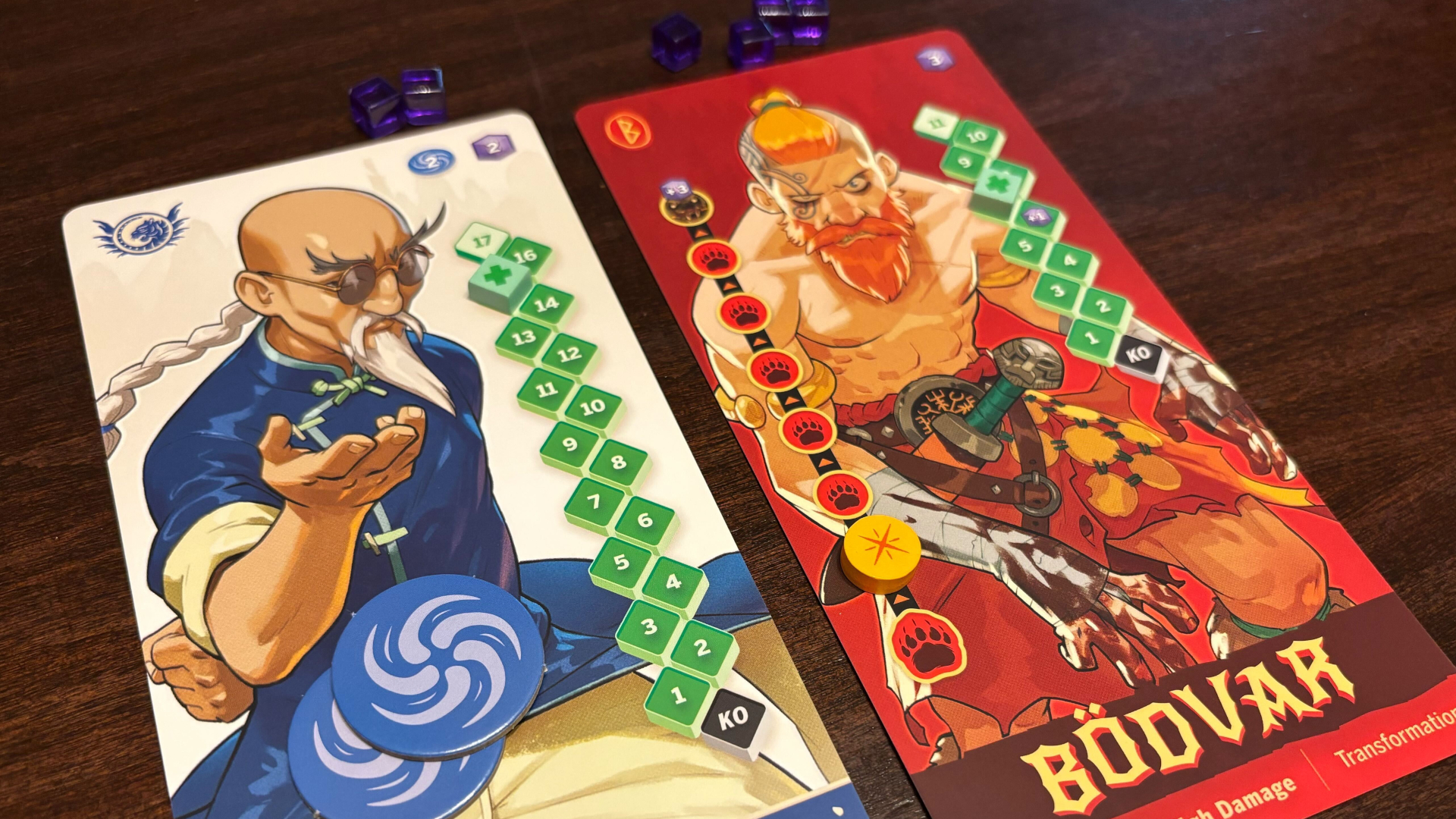 Two cards featuring cartoon character artwork and a grid of numbers against a wooden surface