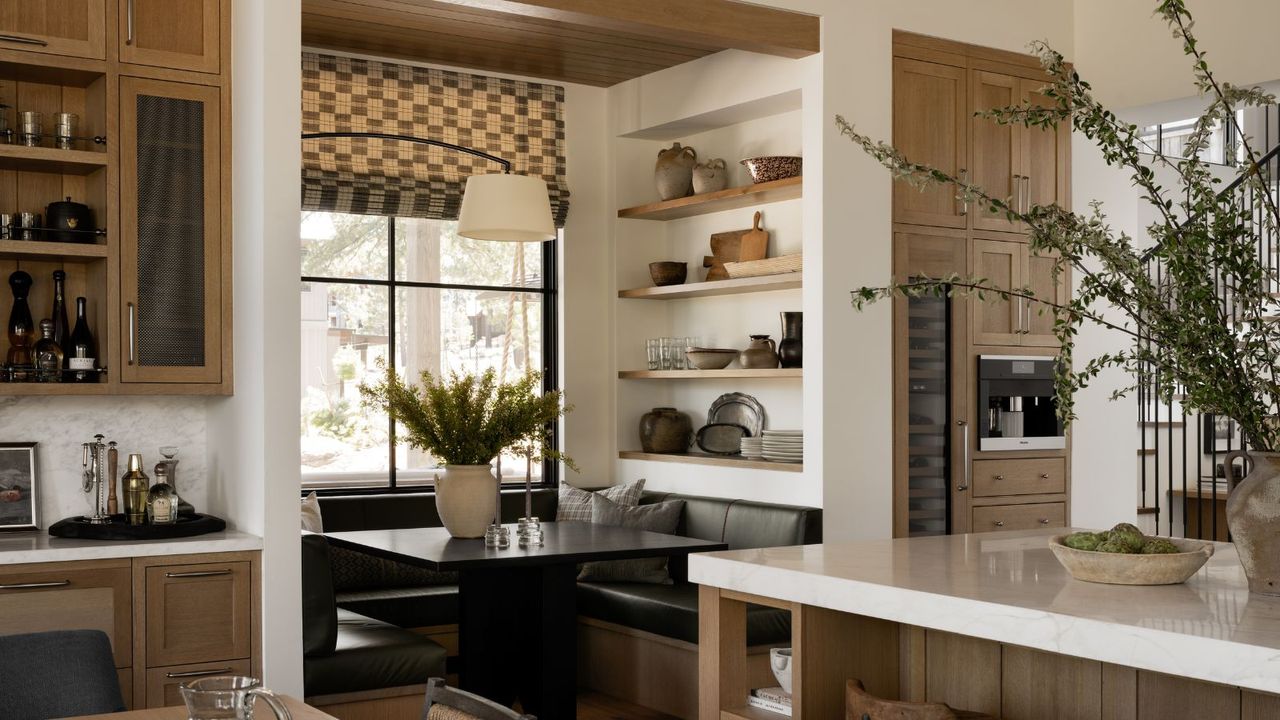 Neutral dining room with breakfast nook with shelves and black table