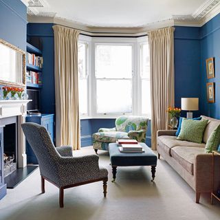 living room with dark blue walls and arm chairs