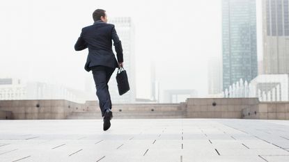 A man in a business suit and carrying a briefcase sprints off into the distance.