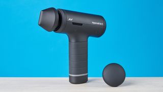Hyperice Hypervolt Go 3 massage gun photographed in front of a blue background