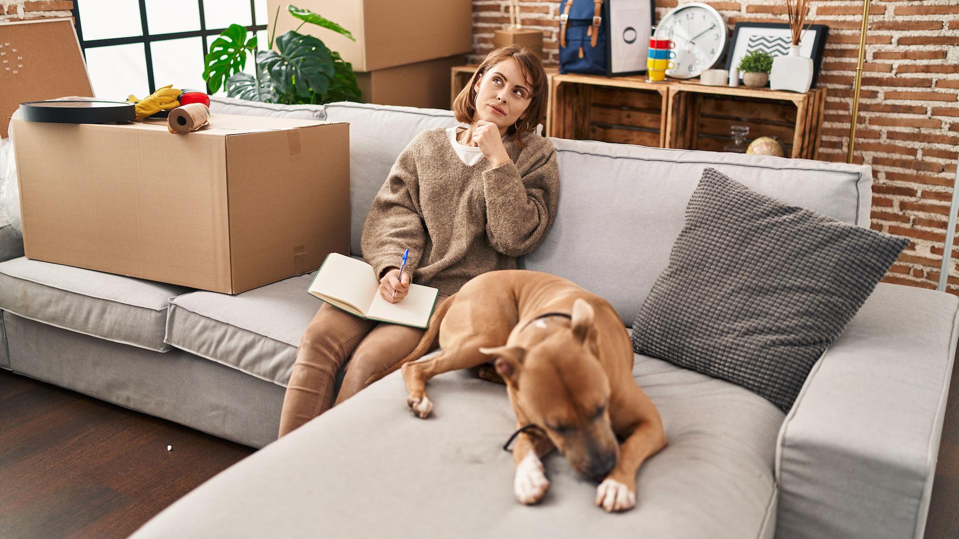 Woman looking at diary, new home, with dog