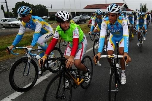 A young fan gets a thrill riding aside Tour leader Alberto Contador.