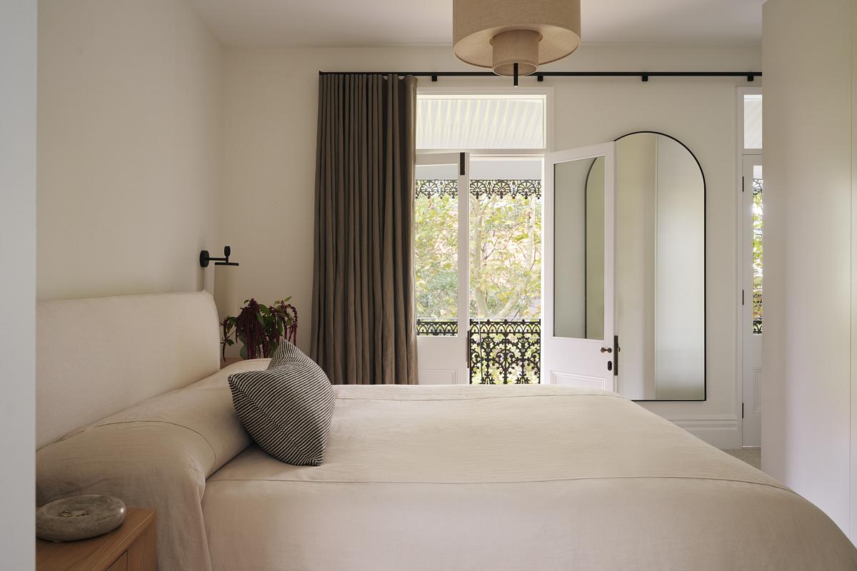 A small bedroom with dark olive colored curtains