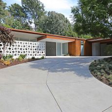Exterior of house with white wall and trees