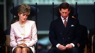 Princess Diana and Prince Charles sat next to one another in black chair both looking rather upset and not looking at each other