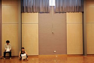 Two people sitting on floor of large room