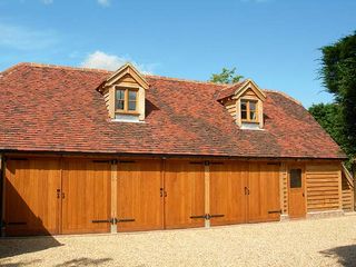 The three-bay Gloucester range garage by Oakwrights has a room above