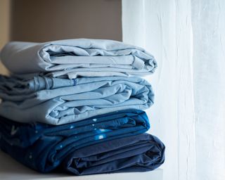 A stack of folded sheets in bedroom