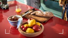 Selection of breakfast items on a kitchen table, including white bread and fruit juice to represent some of the more surprising worst foods for gut health
