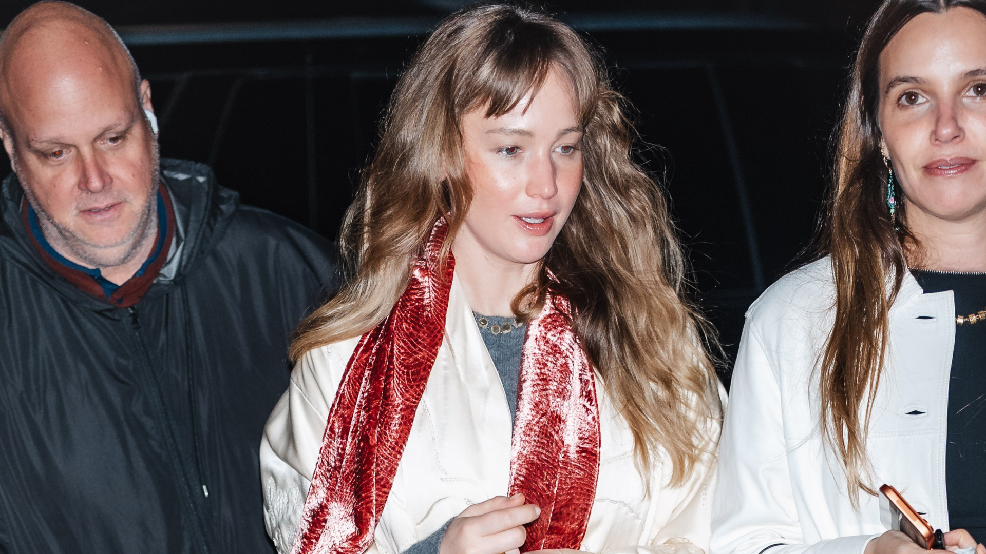 Jennifer Lawrence wore a velvet scarf, a white coat, jeans, and furry flip-flops to a concert in NYC