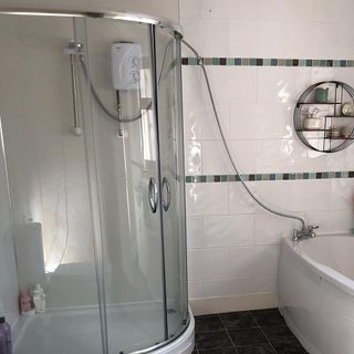 bathroom with white colour bathtub and glass covered bathing area