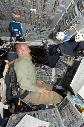 NASA astronaut Garrett Reisman, STS-132 mission specialist, in the commander's seat of the space shuttle Atlantis in 2010.