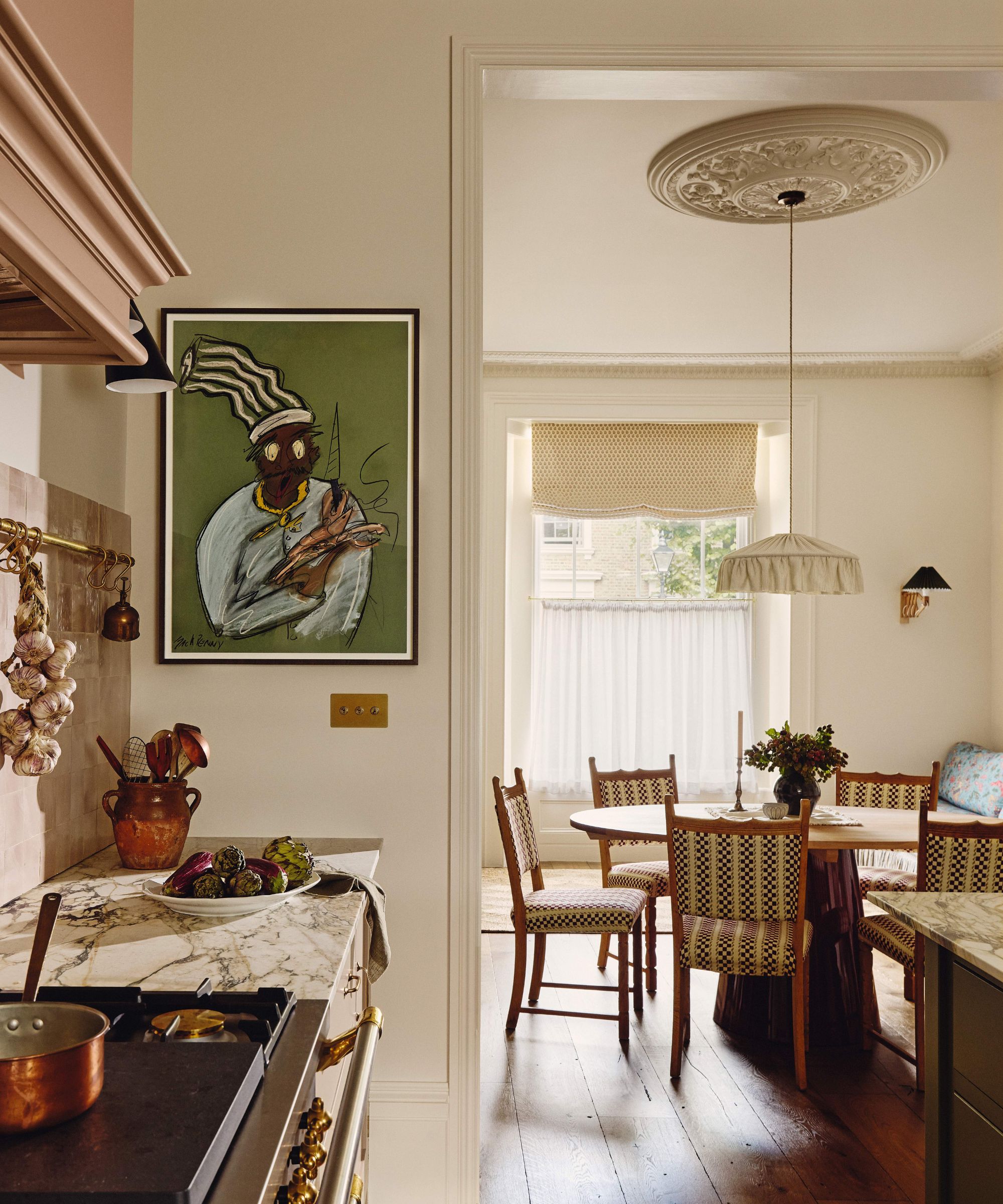 View from a neutral kitchen into an adjoining dining room with a circular dining table and patterned chairs