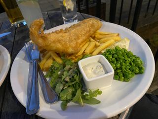 A white plate with fish and chips on it at Magnum in Edinburgh