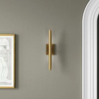 A gold sconce on a light green wall