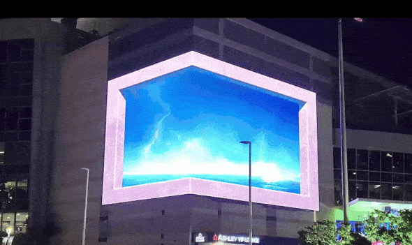 A 3D helicopter comes through a corner LED display on a building. 