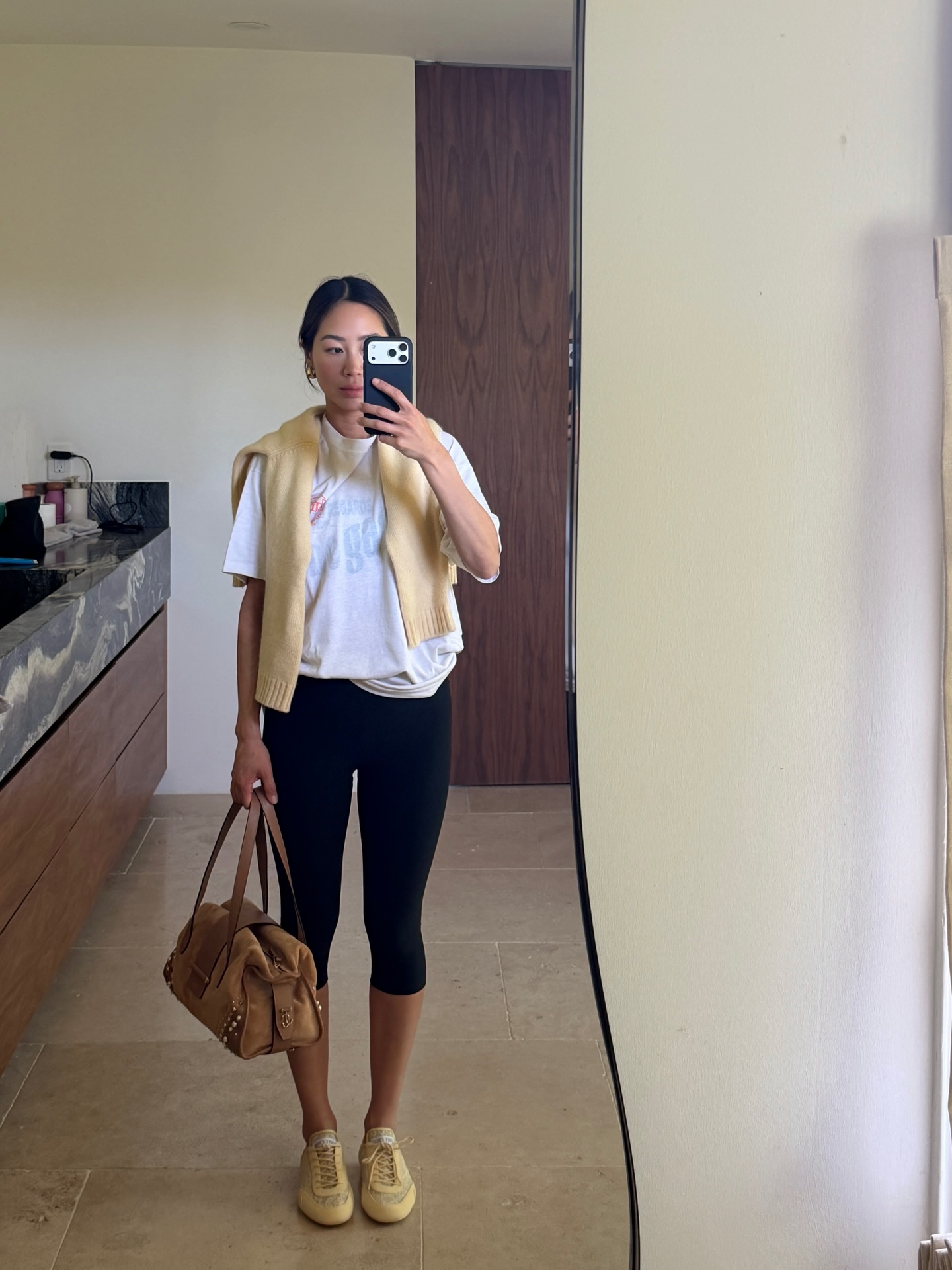 An image of @aimeesong wearing trainers with capri leggings.