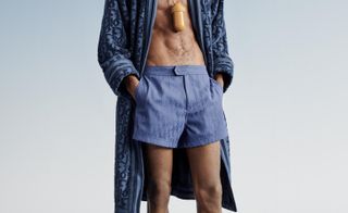 Man in Dior swim shorts, slider sandals and robe