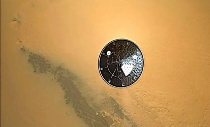 The Curiosity rover's heat shield can be seen falling to Mars' surface as the space lab makes its historic landing onto the Red Planet. 