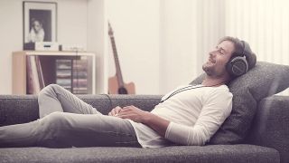 Beyerdynamic Amiron Home headphones review: Man lying on sofa listening to music through headphones