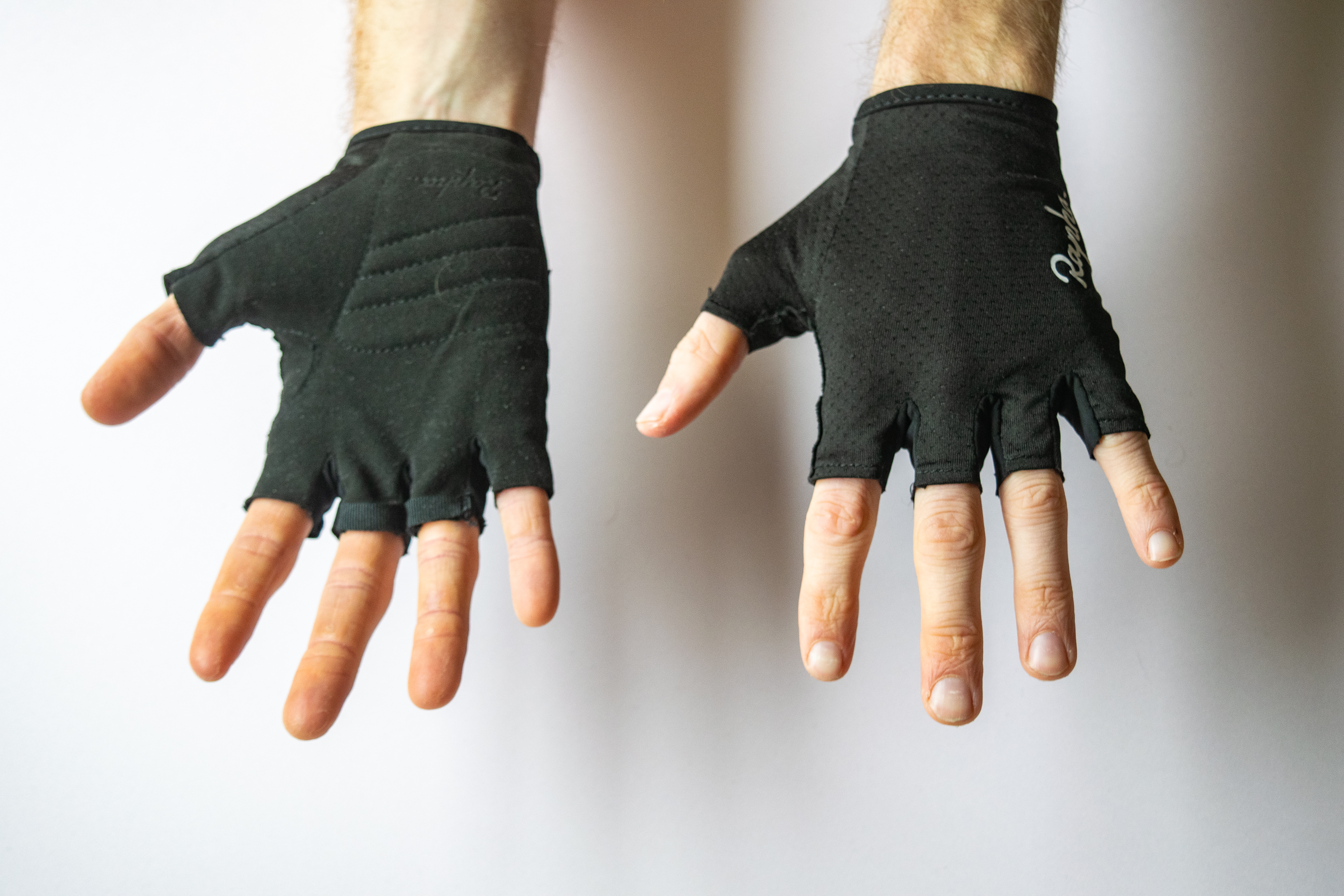 A rider wearing Rapha Core Mitts with hands showing the palm and face of the gloves