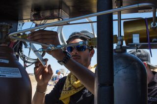 Deepak Atyam adjusts a fitting on the 3D printed rocket engine being tested in the Mojave Desert in April.