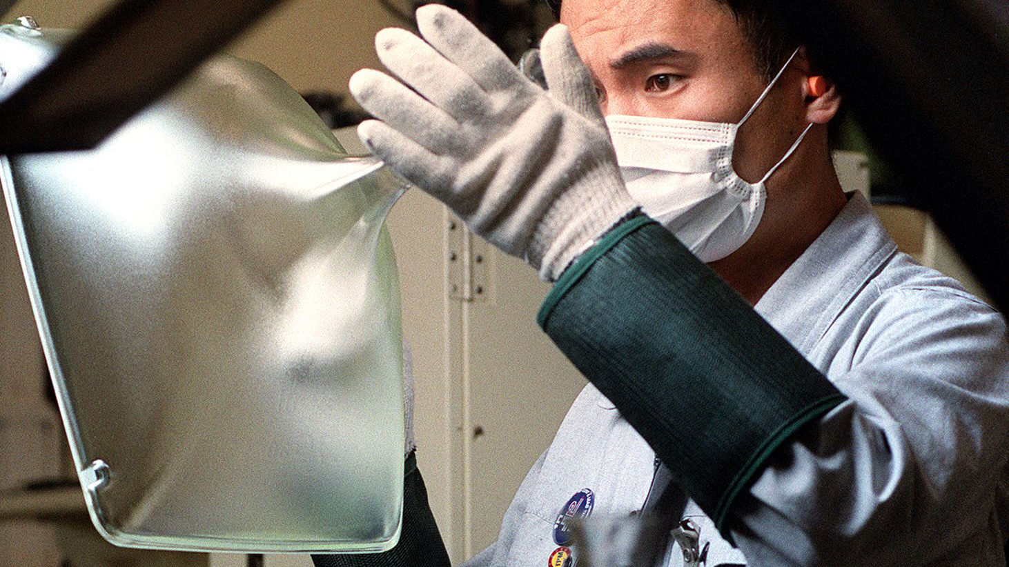 A worker at South Korea's Samsung Electronics Co., checks a cathode ray tube which will be used for a TV or computer monitor, on the production line